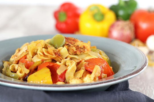 Chicken bites with colorful peppers, fresh thyme and Greek traditional chylopites pasta