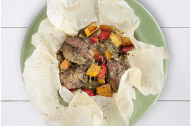 Pork in baking sheet with carrots, colorful peppers and gruyere